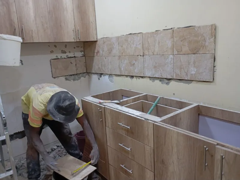 A tradesperson fitting worktops during the room works